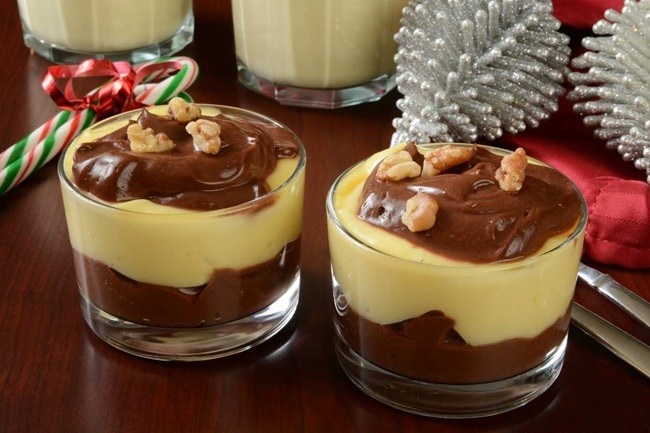 Mesa de Natal posta, com destaque para dois potes de mousse de creme com chocolate, enfeitado com nozes. 