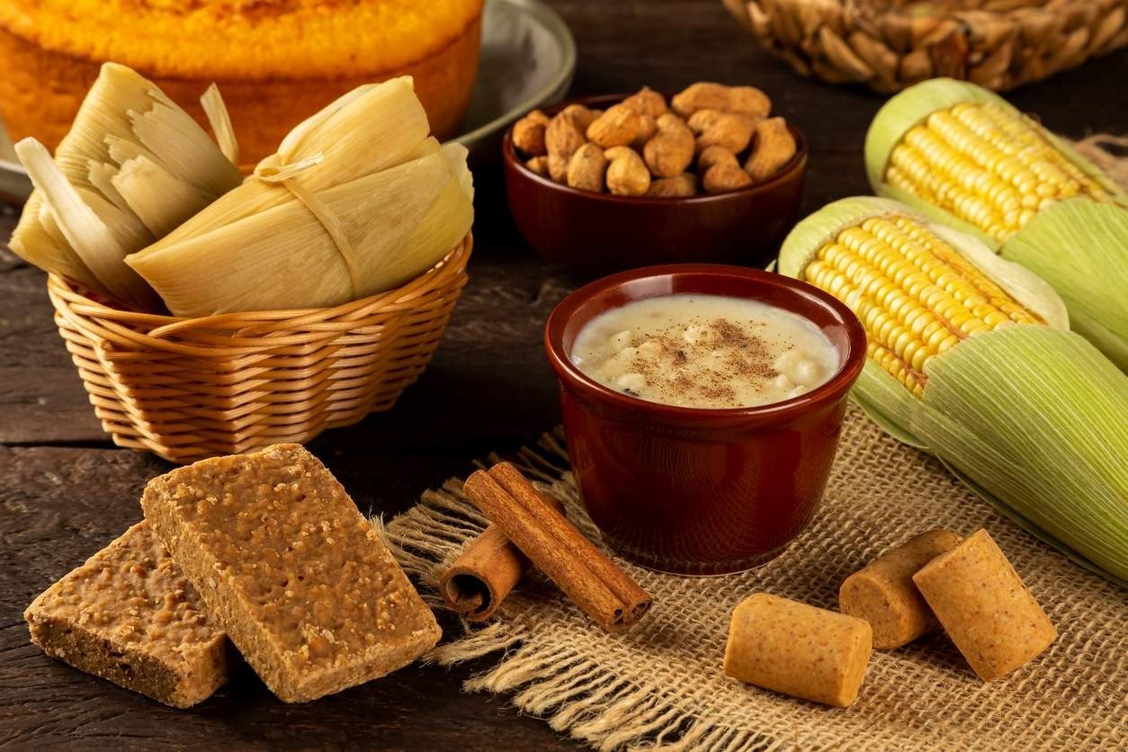 Diversos doces juninos, como canjica, paçoca, pé de moleque, pamonha, bolo de milho