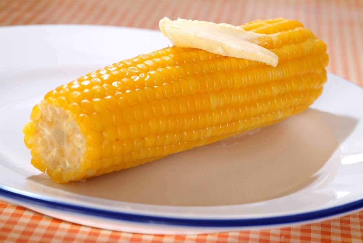 Panela cheia de milho cozido, fumegante.