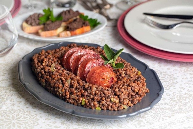 Destaque para prato de lentilha com tomate assado em mesa de ano novo.