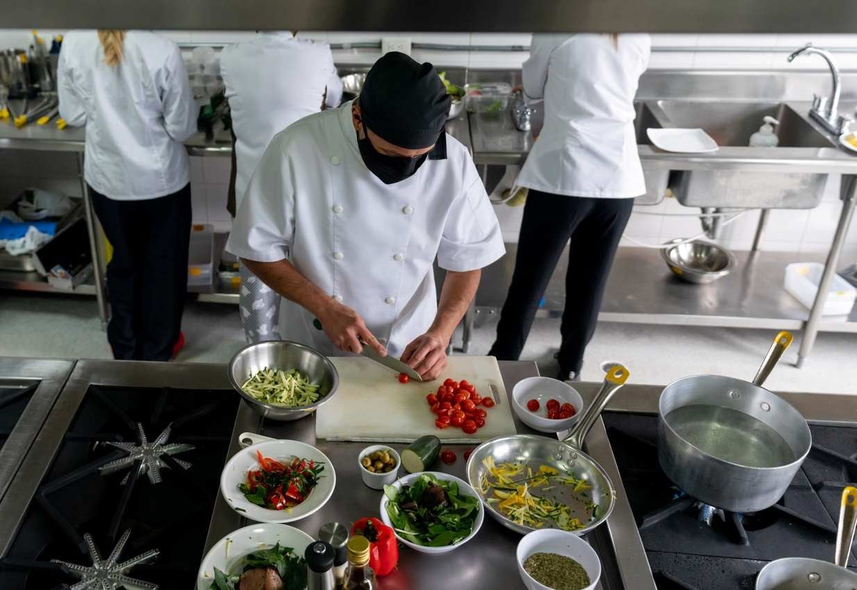 Cozinheiro fazendo mise en place em sua cozinha industrial