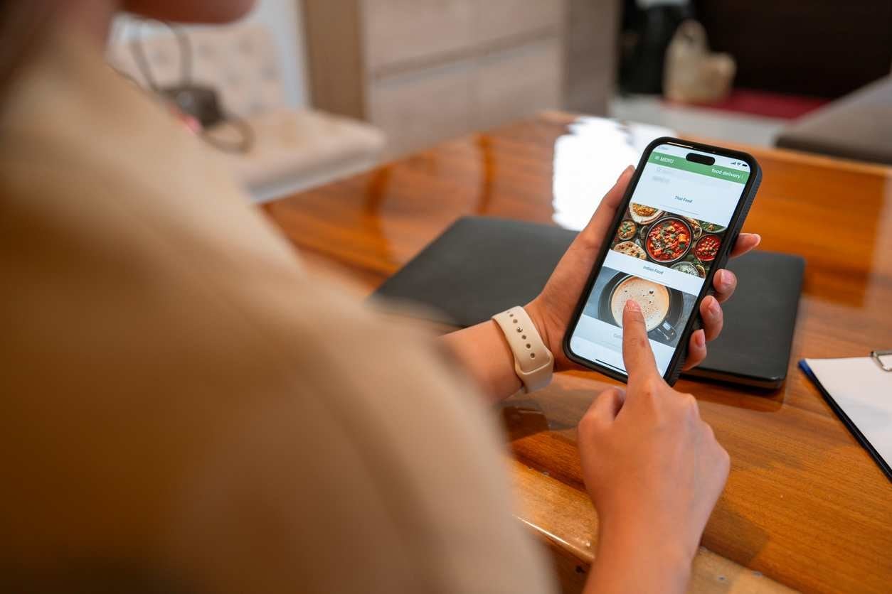 Pessoa usando o WhatsApp, conferindo um cardápio para fazer pedidos em restaurante.