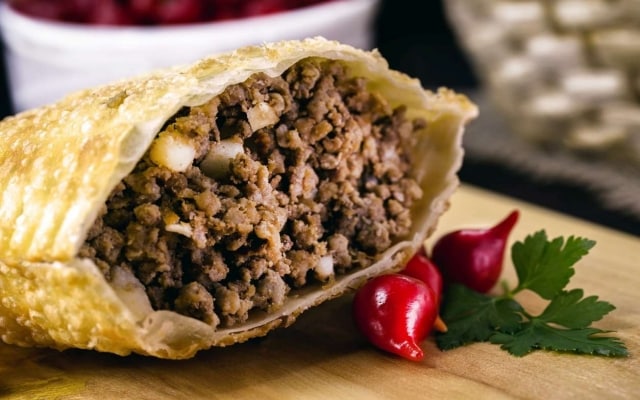 Pastel de carne cortado ao meio, com destaque para o recheio. Pastel de carne cortado ao meio, com destaque para o recheio.