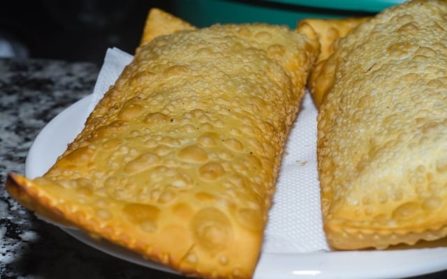 Dois pasteis estão sobre papel toalha, escorrendo Dois pasteis estão sobre papel toalha, escorrendo