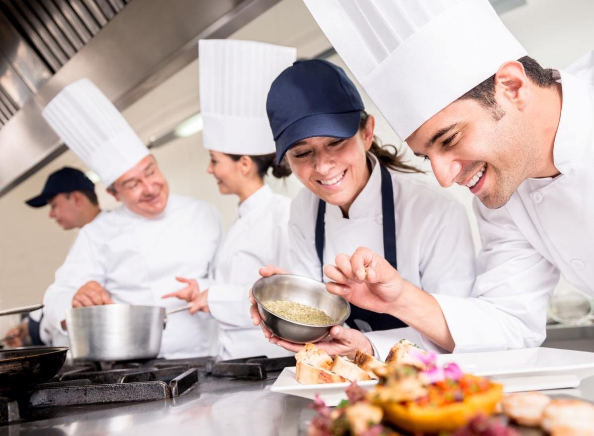 Pessoas felizes trabalhando em cozinha industrial, fazendo empratamento. Pessoas felizes trabalhando em cozinha industrial, fazendo empratamento.