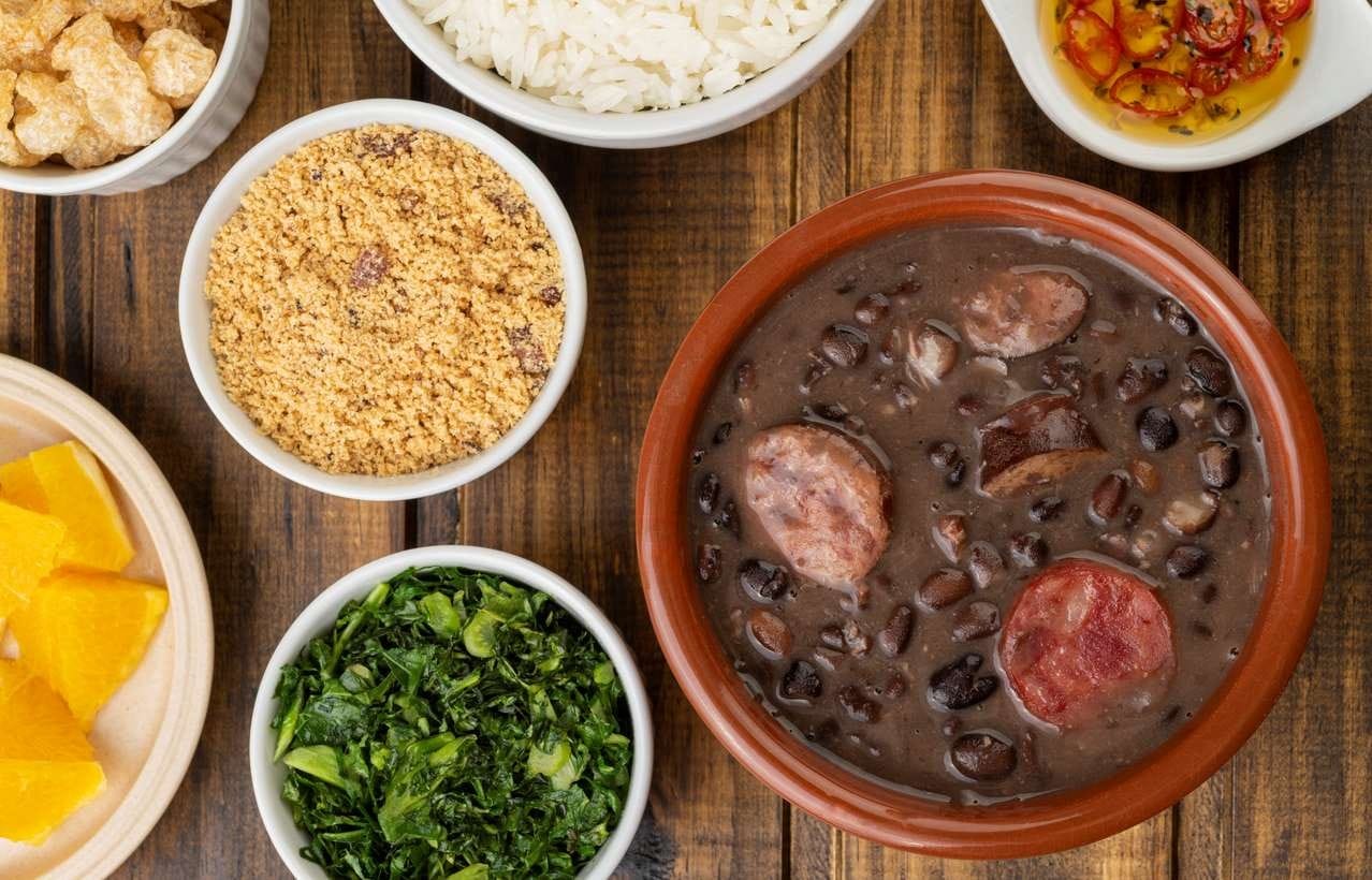 Feijoada individual com acompanhamentos servidos em potes bem divididos