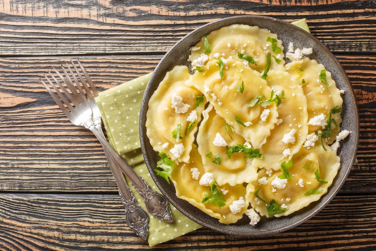 Porção de mezzaluna ao molho de sálvia, coberta com ricota.