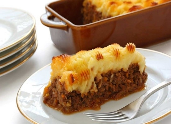 Delicioso escondidinho de carne moída servido em prato, ao lado da porção principal. Delicioso escondidinho de carne moída servido em prato, ao lado da porção principal.
