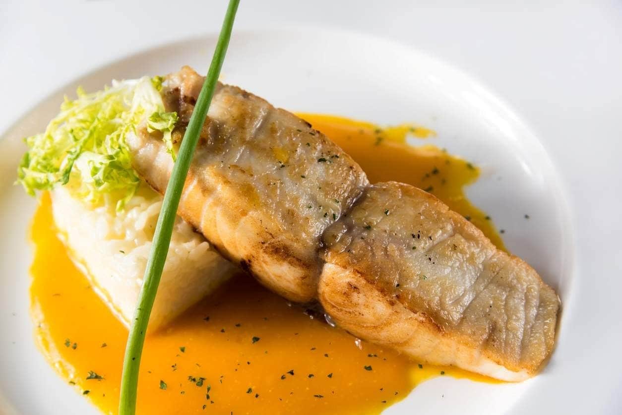 Posta de bacalhau grelhado com arroz, ervas e redução de laranja