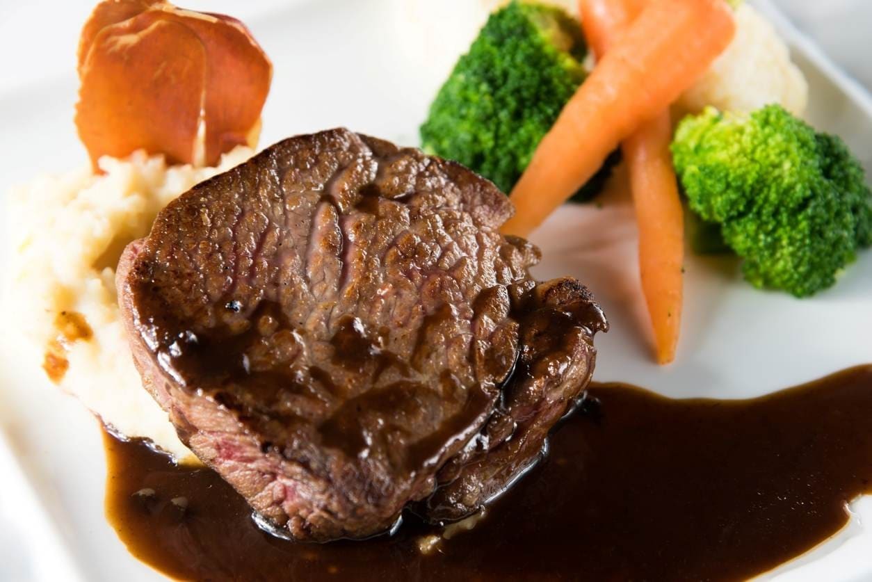 Carne grelhada ao molho de vinho, com purê de batatas, cenoura, brócolis e presunto parma