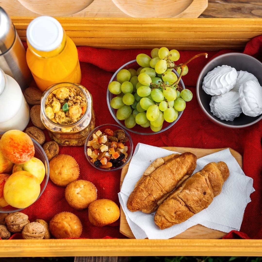 Cesta de café da manhã com frutas, suco, leite, café, sanduíches e suspiro Cesta de café da manhã com frutas, suco, leite, café, sanduíches e suspiro