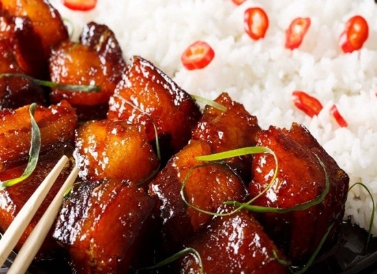 Detalhe de prato oriental com gohan e pedacos de bacon caramelizado, coberto com fios de couve Detalhe de prato oriental com gohan e pedacos de bacon caramelizado, coberto com fios de couve