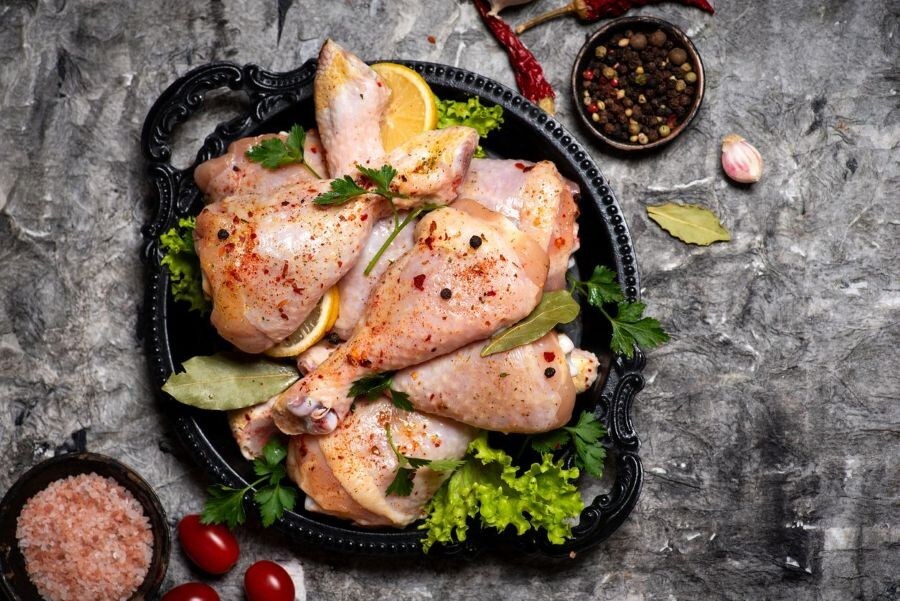 Coxas de frango cruas temperadas com especiarias e ervas frescas. Coxas de frango cruas temperadas com especiarias e ervas frescas.