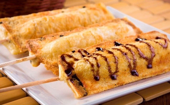 Três crepes suíços em uma bandeja, o último deles está enfeitado com uma redução de tarê Três crepes suíços em uma bandeja, o último deles está enfeitado com uma redução de tarê