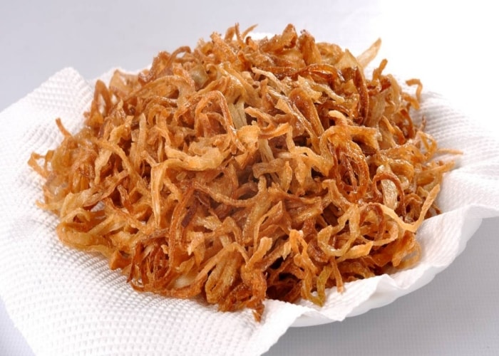 Porção de cebola crispy sobre papel absorvente. Porção de cebola crispy sobre papel absorvente.