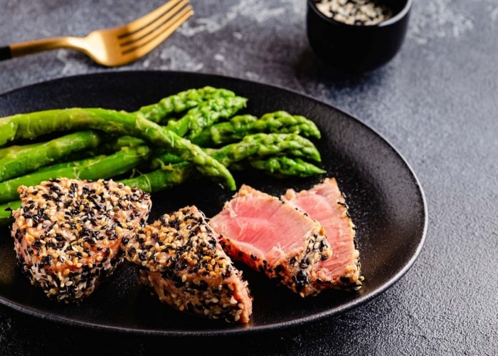 Prato servido de salmão com crosta de gergelim, acompanhado de aspargos Prato servido de salmão com crosta de gergelim, acompanhado de aspargos