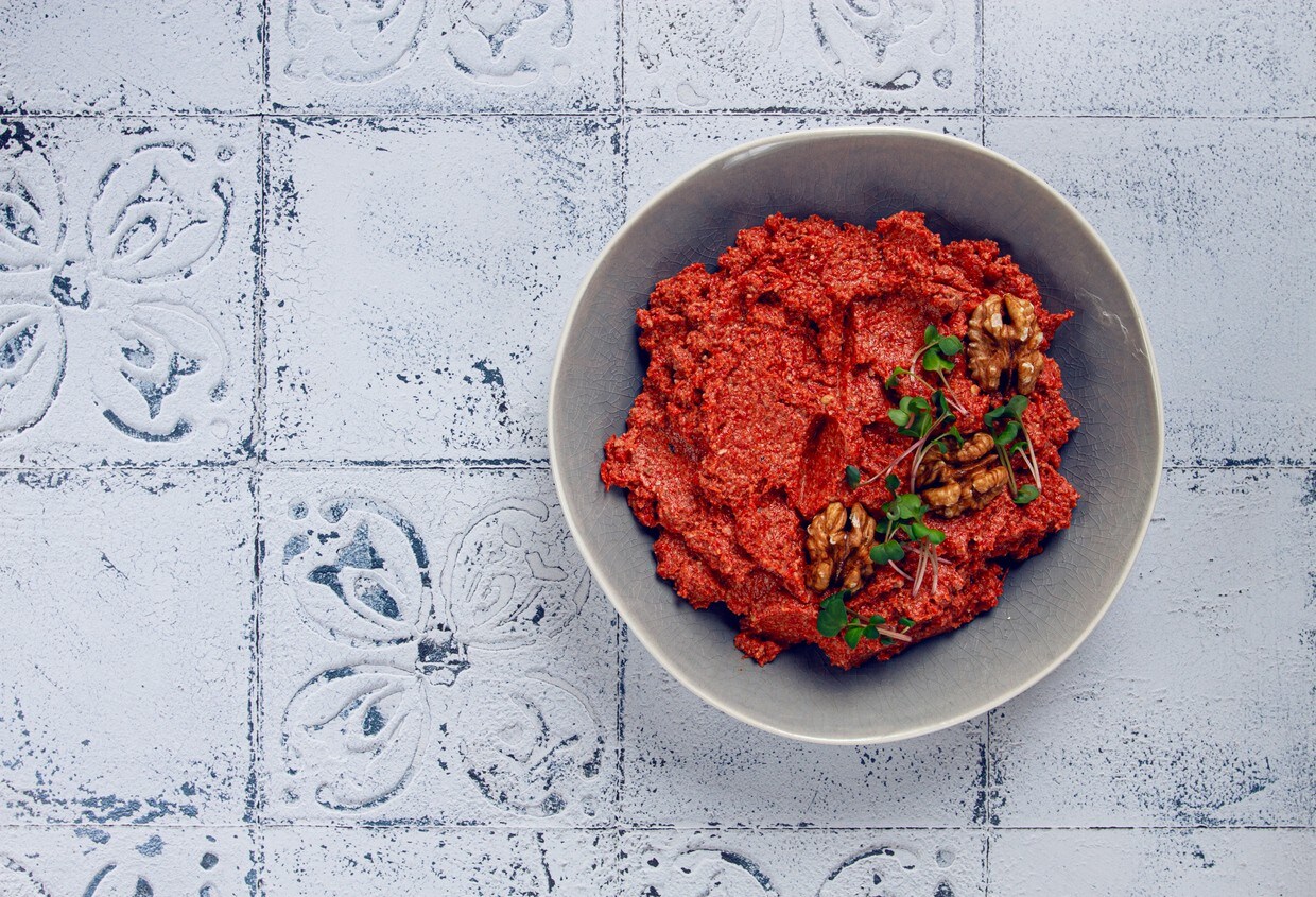 Cumbuca com muhammara, decorada com nozes e brotos de chia. Cumbuca com muhammara, decorada com nozes e brotos de chia.