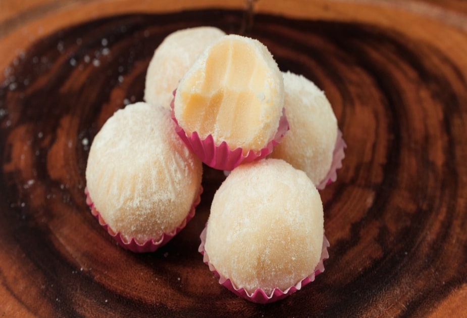 Cinco brigadeiros de queijo coalho, com um deles mordido. Cinco brigadeiros de queijo coalho, com um deles mordido.