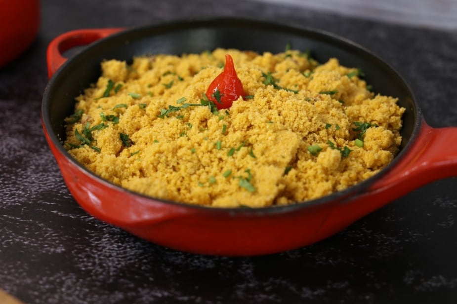 Uma pequena frigideira vermelha, contendo farofa de milho com cheiro verde, enfeitada com uma pimenta biquinho. Uma pequena frigideira vermelha, contendo farofa de milho com cheiro verde, enfeitada com uma pimenta biquinho.